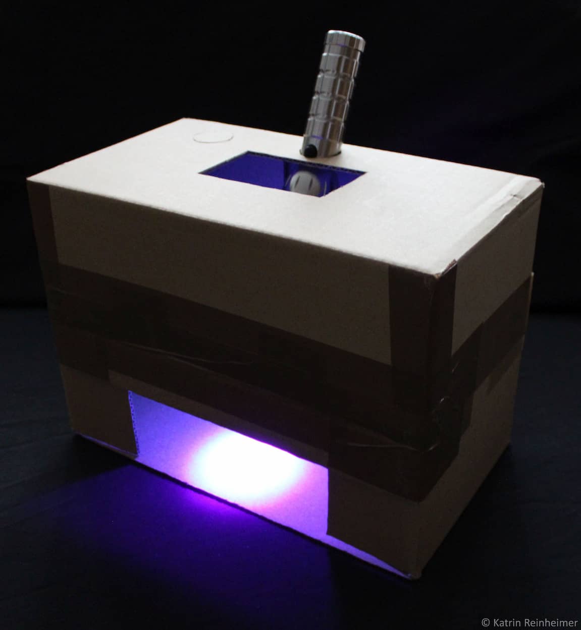Die UV-Box im Dunkeln mit eingeschalteter UV-Lampe.